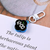A black LED digital keychain watch with a blue casing and silver clasp resting on a white paper.