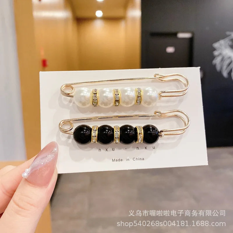 Gold-toned brooch pins featuring white pearls and black onyx stones for apparel customization