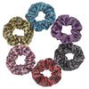Un juego de seis gomas para el pelo con estampado floral de satén en varios tonos de azul, morado, dorado y negro, dispuestos