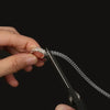 A hand holds an invisible ring size adjuster tool, showing the mechanism for adjusting ring size.