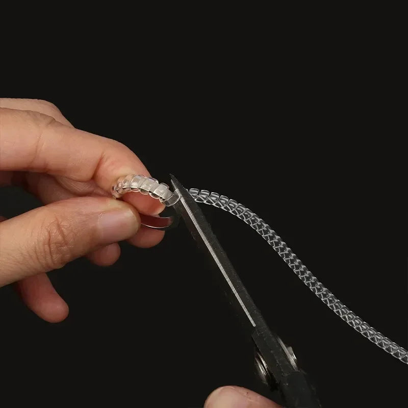 A hand holds an invisible ring size adjuster tool, showing the mechanism for adjusting ring size.