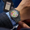 A close-up of a black retro luminous quartz wristwatch worn on a wrist, resting near a blue and white plaid sleeve.