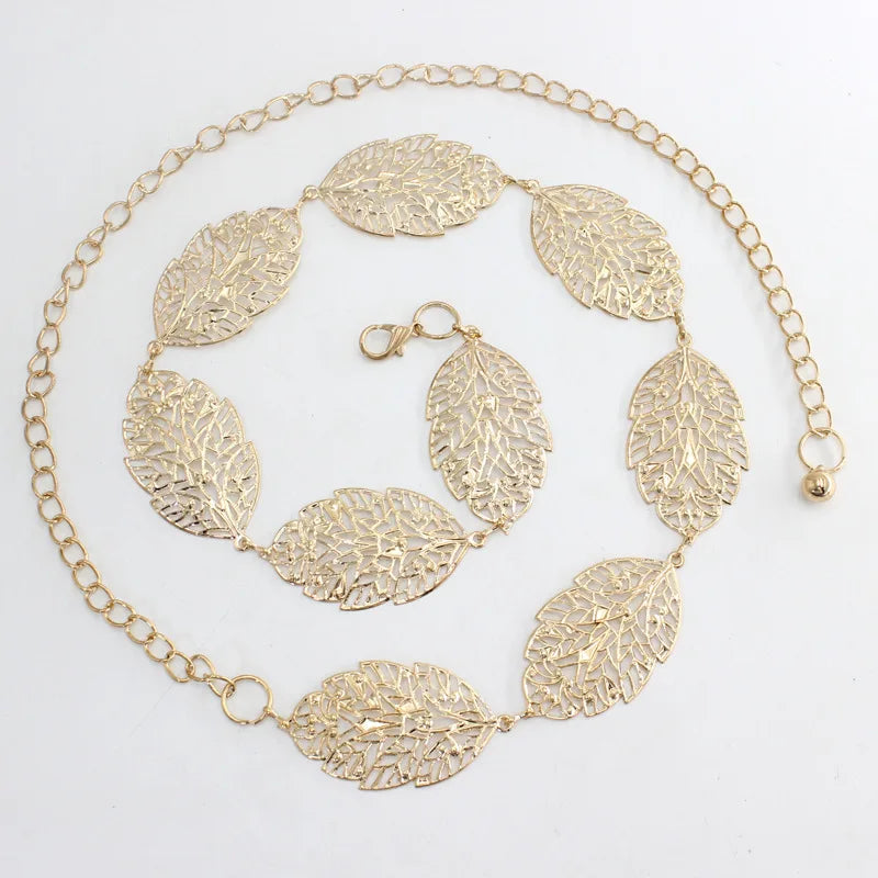 Cinturón de cadena metálica de tono dorado con colgantes en forma de hoja.