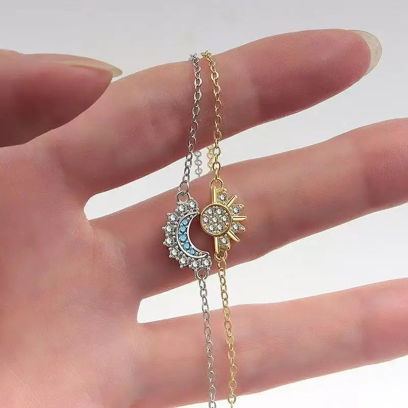 Eine Hand hält ein Paar verstellbare Sonne-und-Mond-Paarschmuck aus gold- und silberfarbenem Metall.
