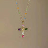A colorful zircon cross pendant necklace featuring various colored gemstones on a gold chain.