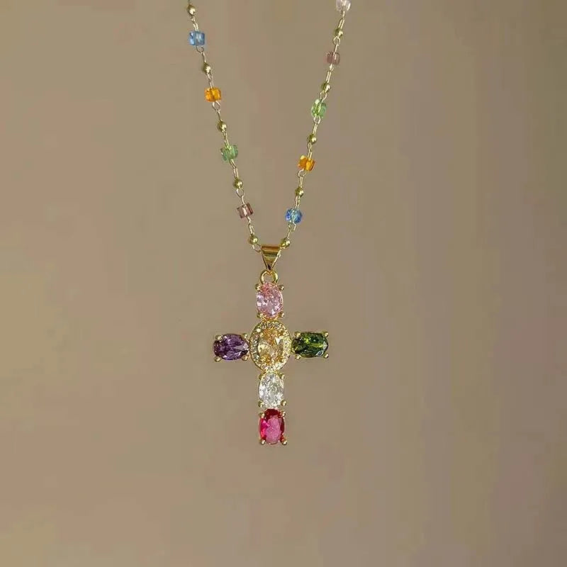 A colorful zircon cross pendant necklace featuring various colored gemstones on a gold chain.