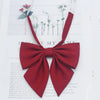A solid red cotton bow tie tied in a bow shape, displayed against a white background.