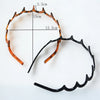 A black anti-slip toothed hair accessory with a curved design and marked dimensions.