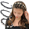 Une femme porte des boucles d'oreilles doubles noires et perles, stylées en tresse.