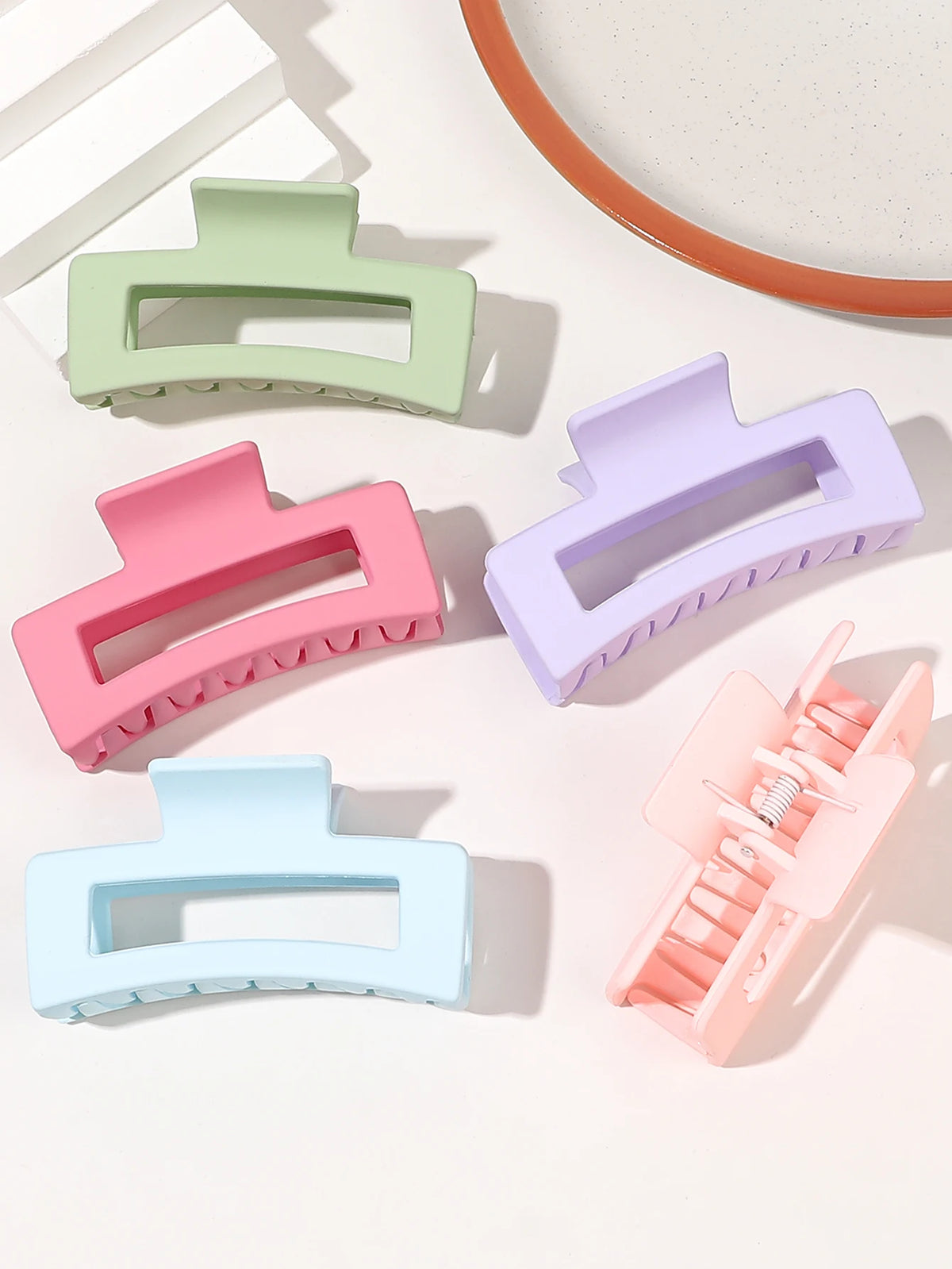 A set of seven square hair claw clips in various pastel colors including mint green, pink, lavender, and light blue.