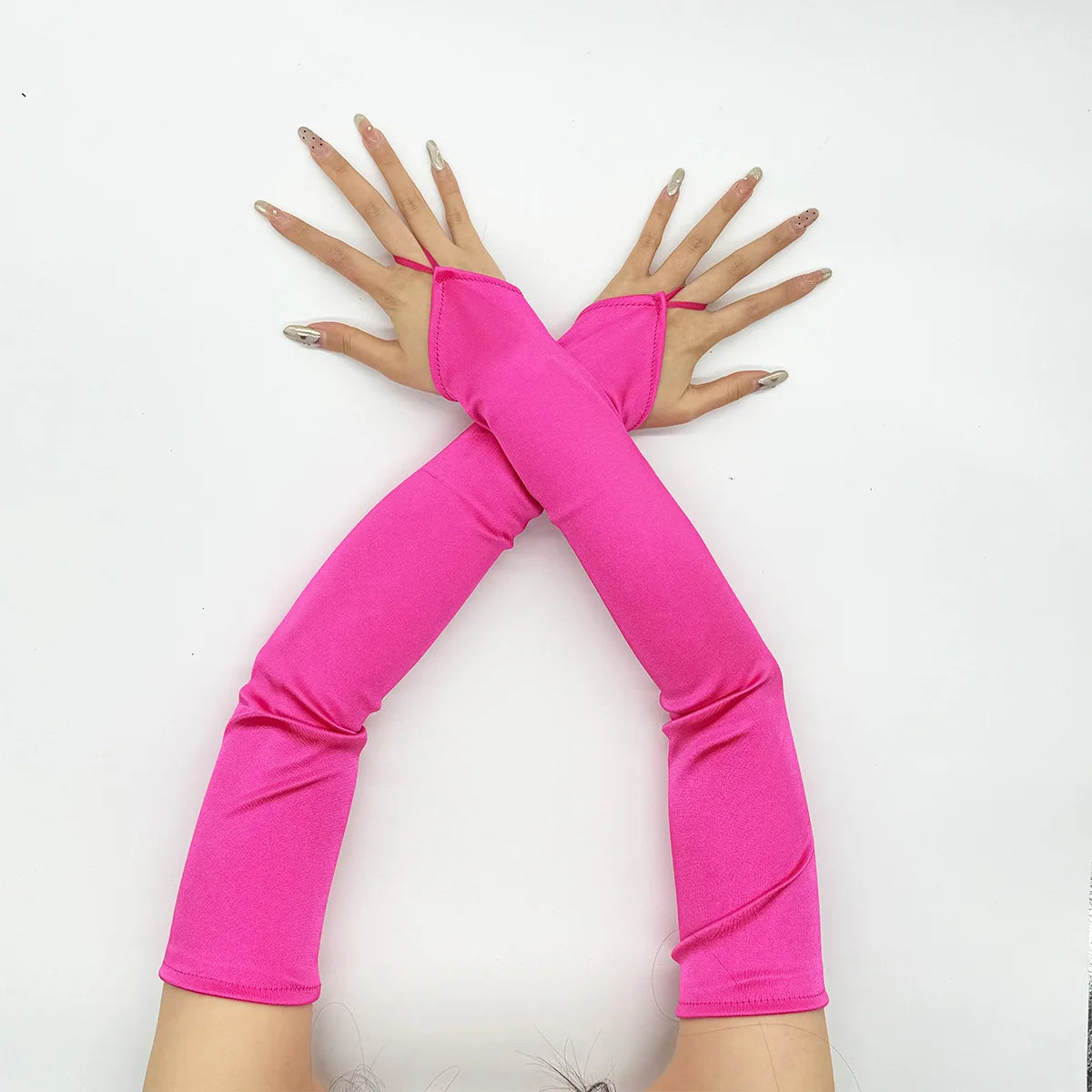 A pair of bright pink satin fingerless gloves worn on the hands, displayed against a white background.