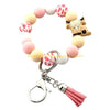 A silicone wristlet keychain featuring a decorative border of pink and white patterned cow shapes.