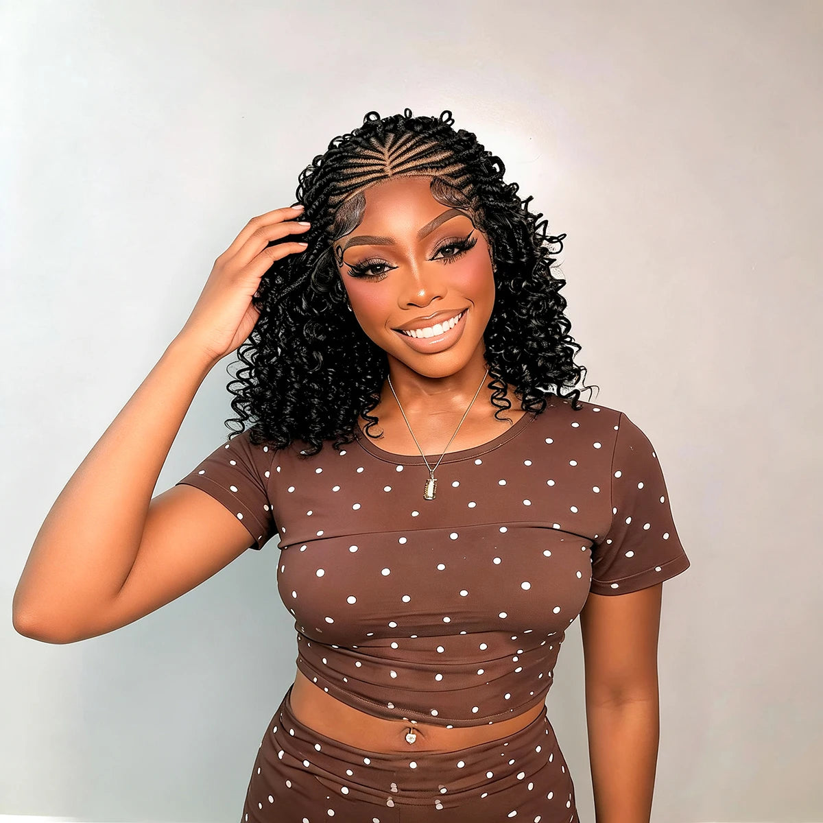 Femme modélisant une perruque tressée cornrows naturelle de 16 pouces avec un haut et un bas assortis marron.
