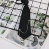 A black classic chain necktie with a silver chain and pendant displayed on a grid of nature photos.