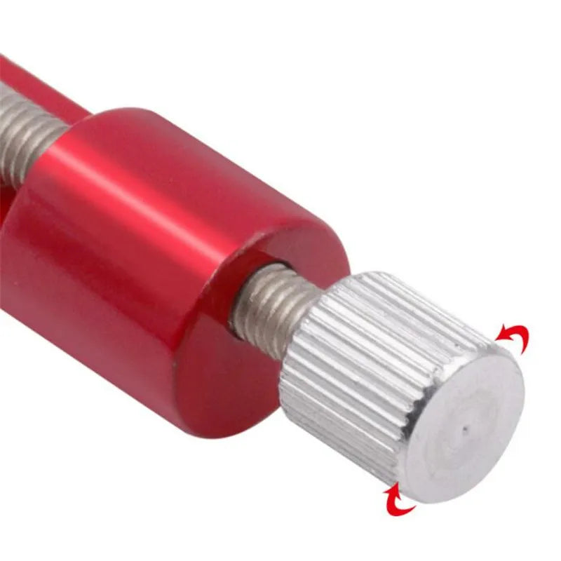 A close-up view of a red and silver precision metal watch strap adjuster tool.