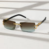 A pair of trendy frameless rectangular sunglasses with gold accents resting on a white surface.