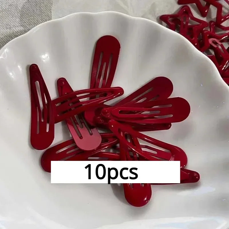 A set of 10 red star snap clips for hair and barrettes displayed on a white plate.