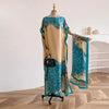 A woman wearing a long, flowing floral butterfly peacock cape shawl displayed on a mannequin.