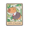 An enamel pin featuring a brown bear wearing a suit surrounded by stacks of money, labeled CAPY-ITALISM.