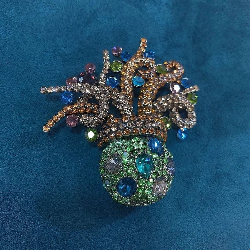 Broche florale en cristal élégante avec des pierres précieuses bleues, violettes et vertes.