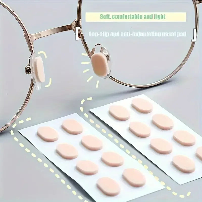 Un par de gafas con almohadillas nasales antideslizantes y anti-indentación junto a varias almohadillas de reemplazo.