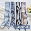 A set of four silk satin hair and bag accessories featuring blue, black, and white checkered patterns