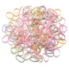 A pile of colorful elastic hair ties in pink, yellow, and blue shades.