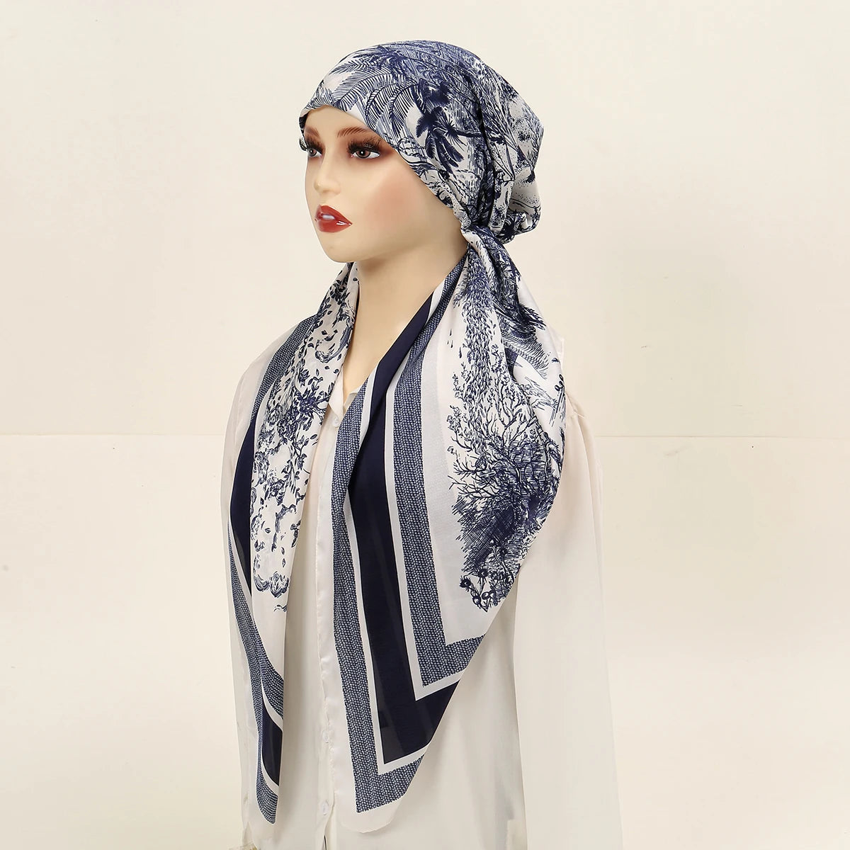 A woman models a satin silk hijab headband cap with a blue and white floral print and striped fabric.