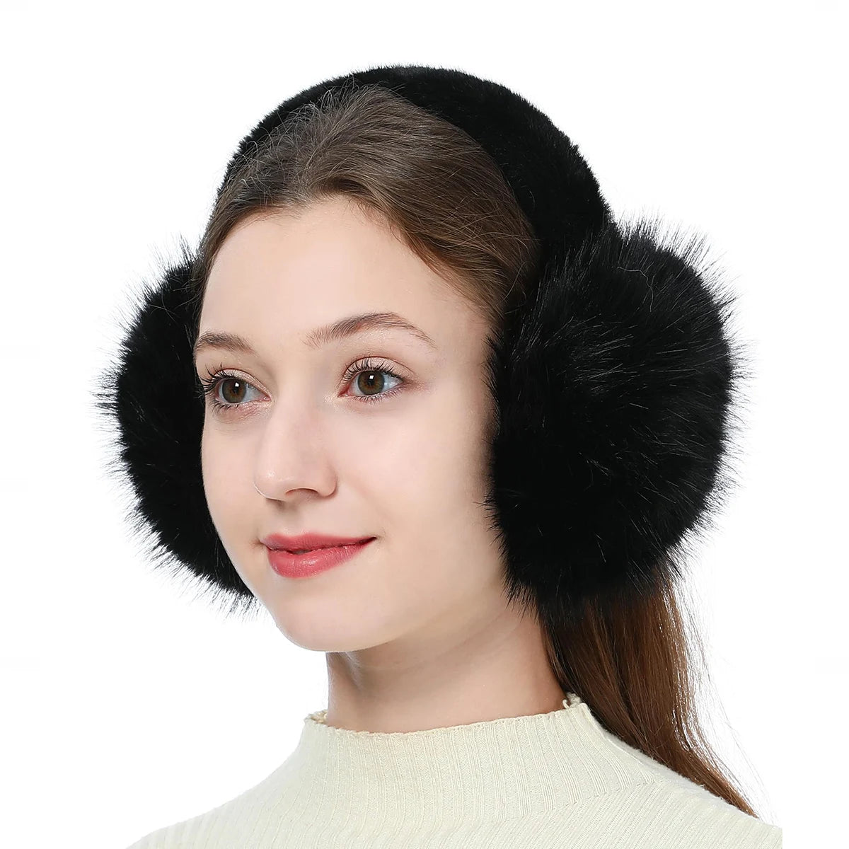 A woman wearing black faux fur earmuffs with long brown hair and a cream-colored top.