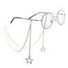 A pair of clear-framed eyeglasses with a delicate gold pearl lanyard and chain.