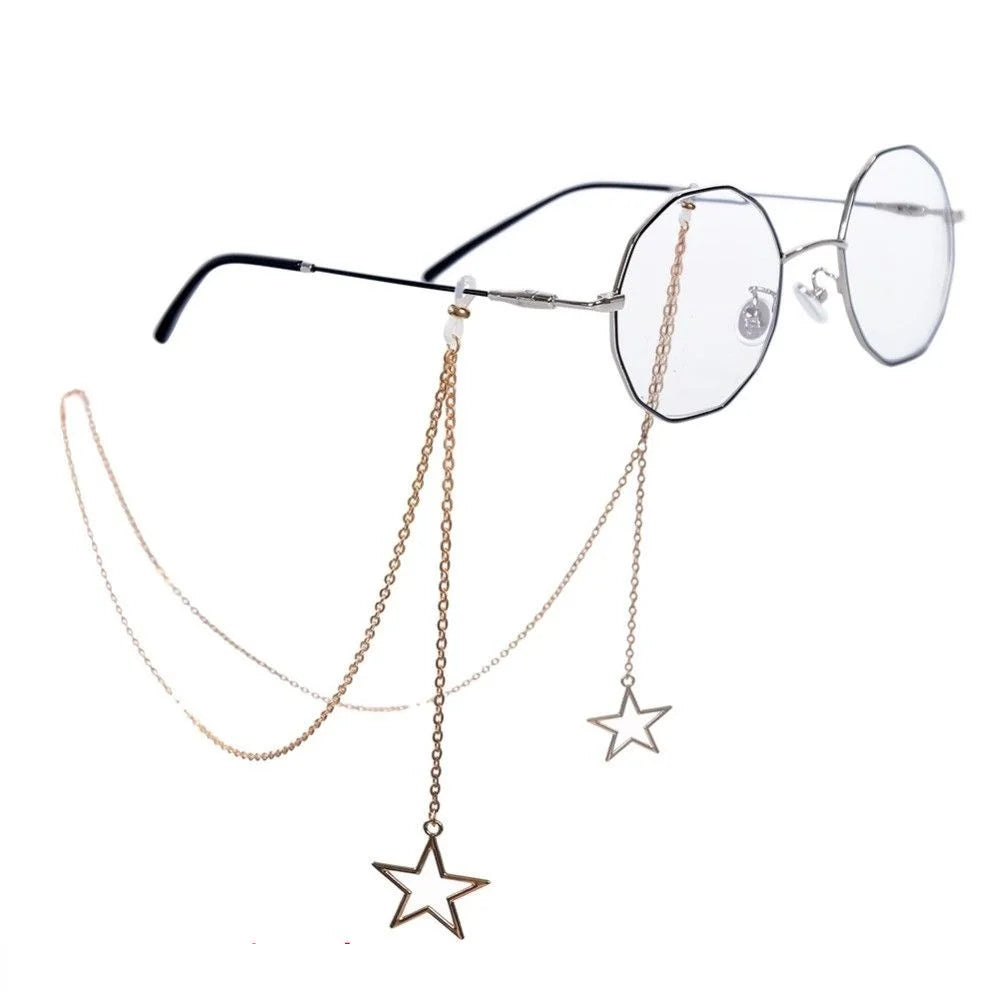 A pair of clear-framed eyeglasses with a delicate gold pearl lanyard and chain.