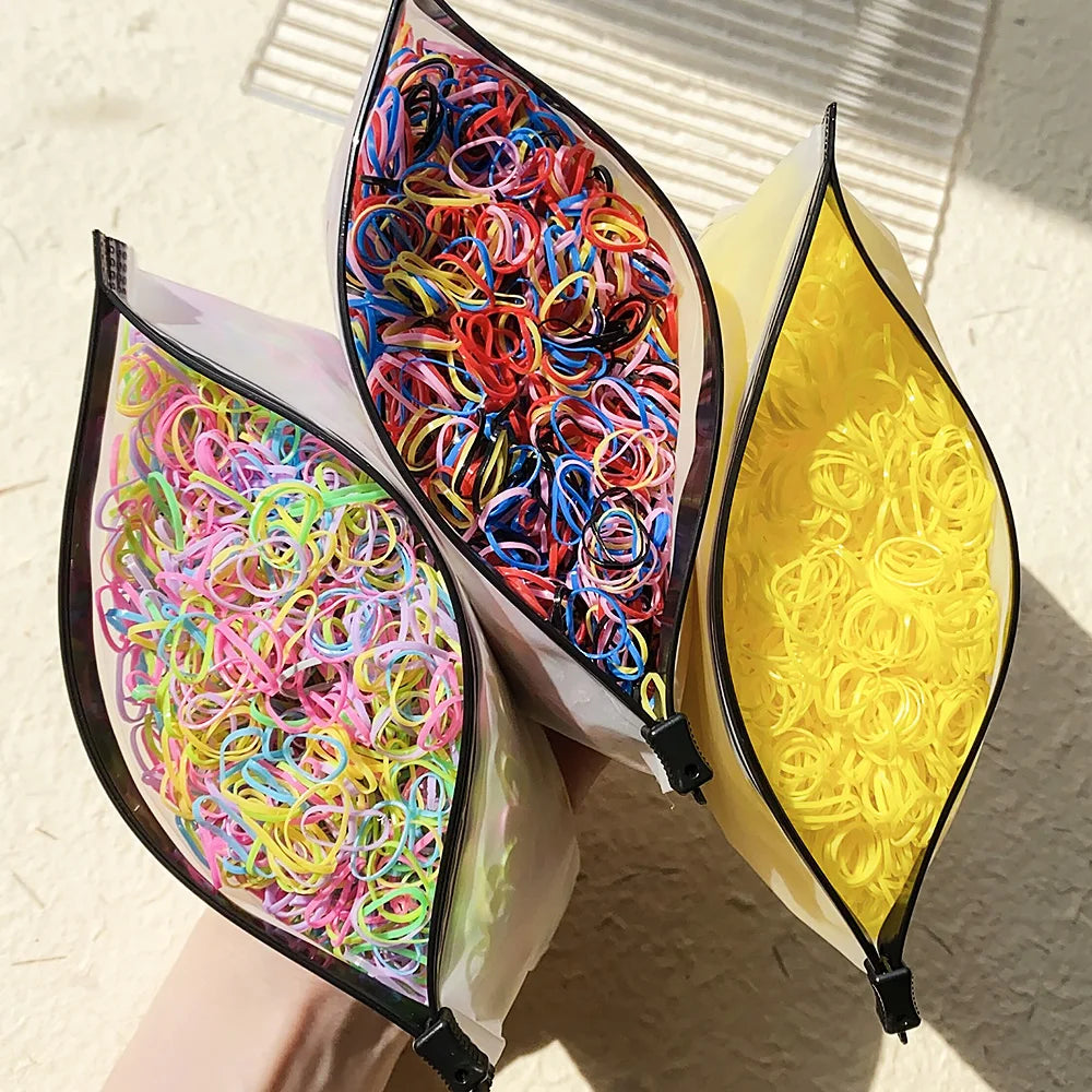 A collection of colorful disposable rubber hair ties in various shades are displayed in translucent packaging.