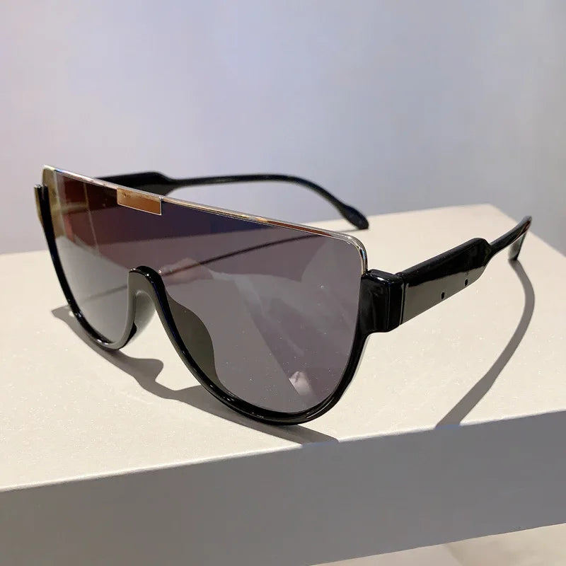 A pair of vintage cat eye sunglasses with dark lenses and black frames resting on a white surface.