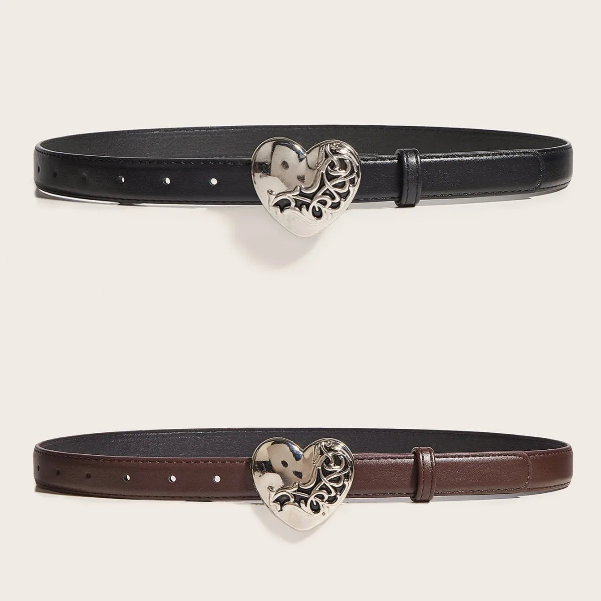 Cinturón de cuero negro con hebilla metálica en forma de corazón plateado.