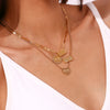 A close-up of a gold plated rectangle pendant necklace with multiple layered chains worn on a woman's neck.