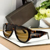 Brown leopard print sunglasses resting on a light wooden surface next to a dark box.