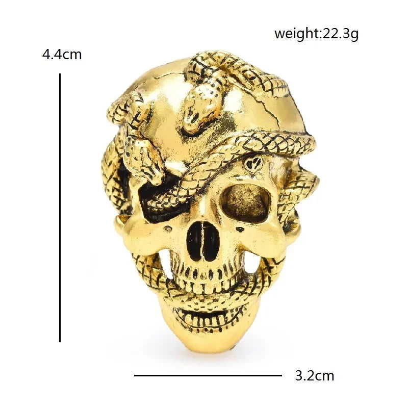 Broche calavera de strass de color dorado con diseño detallado de calavera y serpiente.