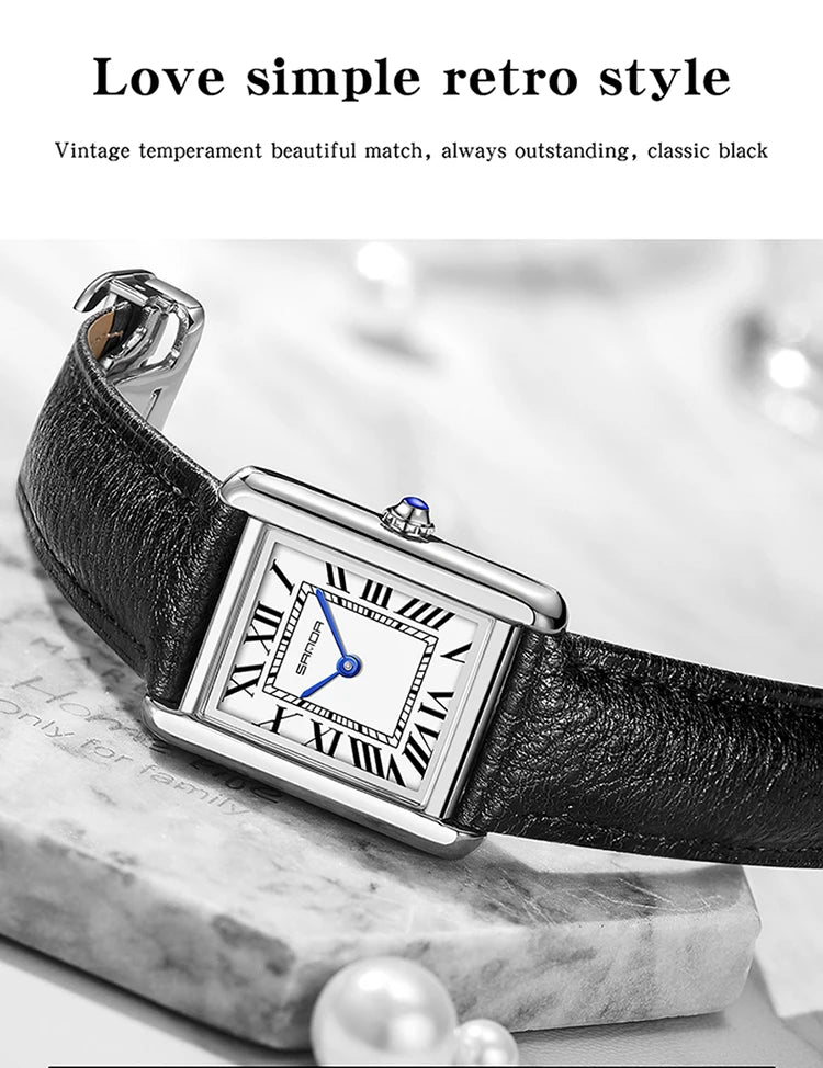 Nahaufnahme einer schwarzen Lederarmbanduhr mit silbernem Gehäuse und blauem Zifferblatt auf Marmor.