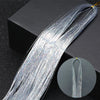 A bundle of silver glitter hair extensions for braiding laid across a dark surface.