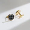 A pair of elegant gold cufflinks featuring a black and white geometric pattern.