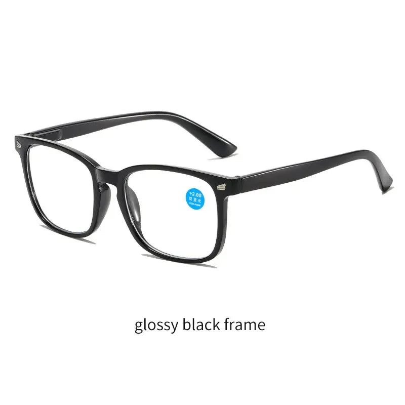 Un par de gafas de lectura negras brillantes contra un fondo blanco.