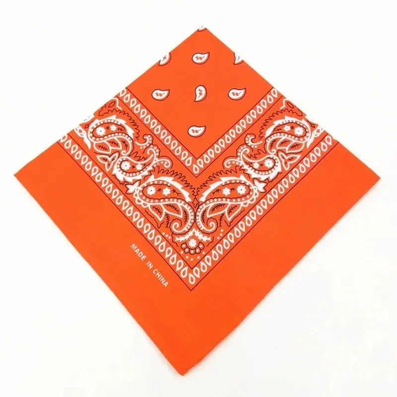 Orange cotton bandana scarf with white paisley pattern folded diagonally