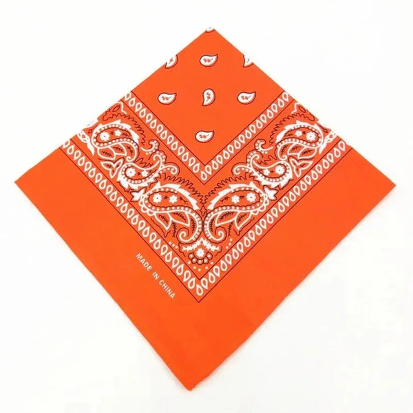 Orange cotton bandana scarf with white paisley pattern folded diagonally