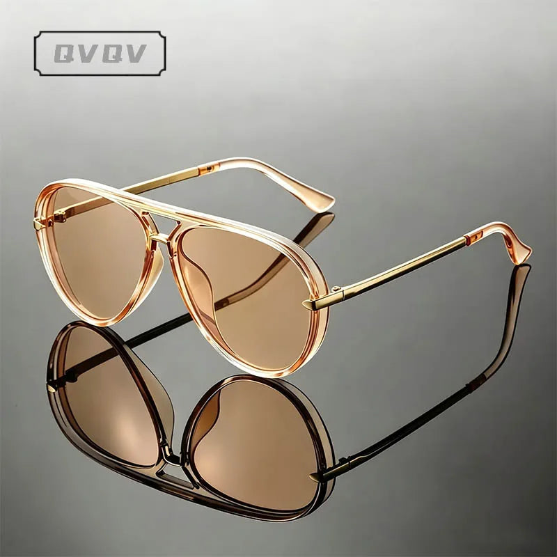 Lunettes de pilote en métal vintage avec verres teintés rose or, présentées sur une surface réfléchissante.