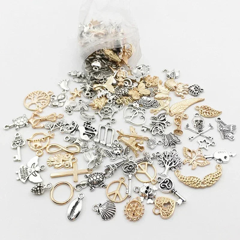 Eine Sammlung von silbernen und goldenen tibetischen Mischanhängern für DIY-Schmuck.