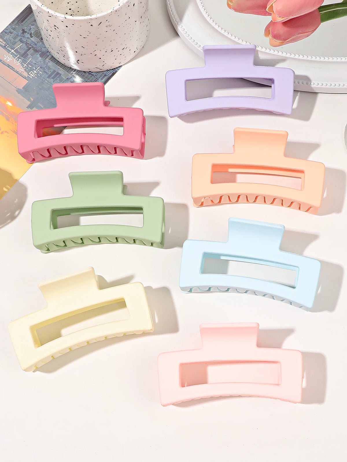 A set of seven square hair claw clips in various pastel colors, including pink, purple, mint green, and peach.