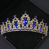 Couronne diadème dorée avec des gemmes bleu profond et des détails floraux complexes.