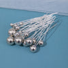 A collection of 18 silver faux pearl hair pins with thin wires arranged on a blue surface.