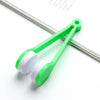 A green portable multifunctional eyeglass cleaning kit with a brush is shown on a white background.