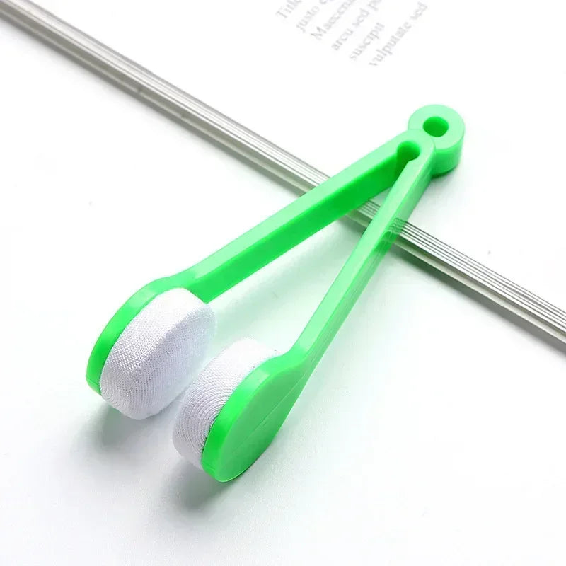 A green portable multifunctional eyeglass cleaning kit with a brush is shown on a white background.